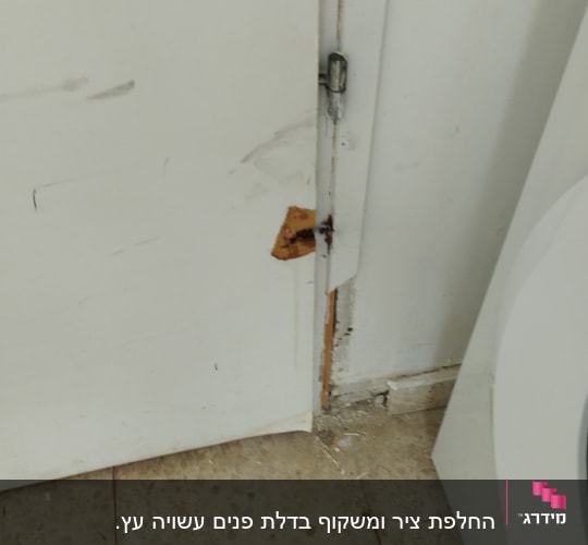 דלת לבנה עם נזק ותיקון ליד הציר